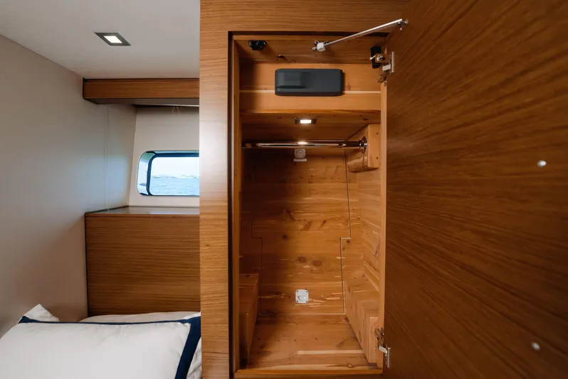  Yacht Photos Pics 2017 Hatteras M75 Panacera cabin with open wooden closet and window view.
