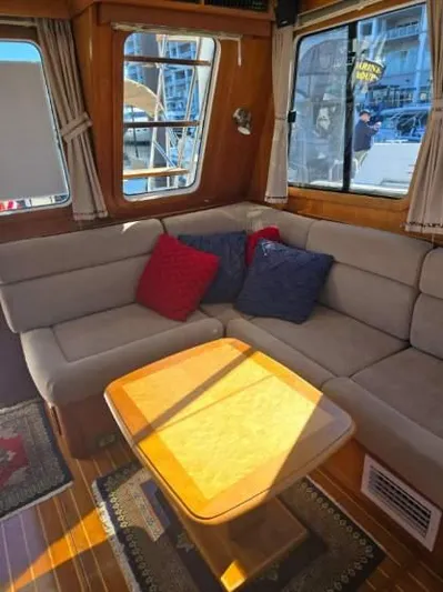 Juju Yacht Photos Pics 2004 Sabre 36 Flybridge Fast Trawler interior with cozy seating and wooden table.