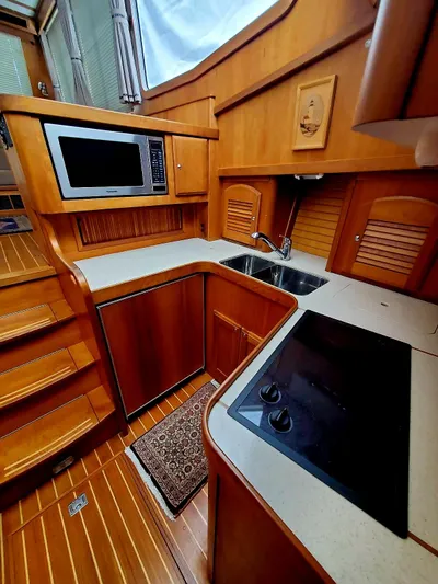 Juju Yacht Photos Pics 2004 Sabre 36 Flybridge Fast Trawler kitchen with wood cabinetry, stove, and microwave.
