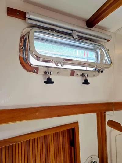 Juju Yacht Photos Pics Port window inside 2004 Sabre 36 Flybridge Fast Trawler, featuring wood accents and metal frame.