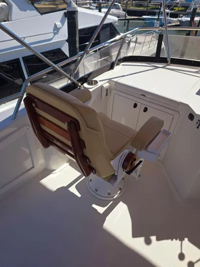 Juju Yacht Photos Pics 2004 Sabre 36 Flybridge Fast Trawler helm seat with wooden accents and marina view.