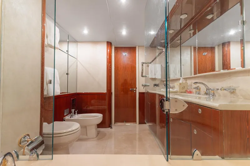 Fomo2 Yacht Photos Pics Luxurious bathroom in 2002 Lazzara 80 Skylounge yacht with elegant wood and glass accents.