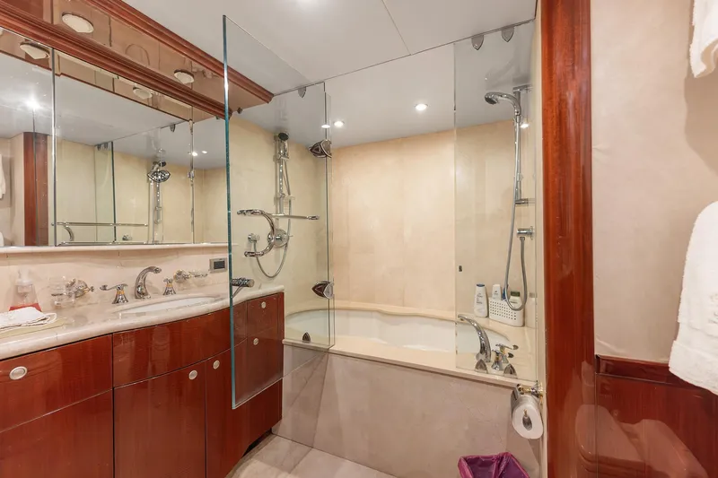 Fomo2 Yacht Photos Pics Luxurious bathroom on 2002 Lazzara 80 Skylounge yacht with glass shower and elegant fixtures.