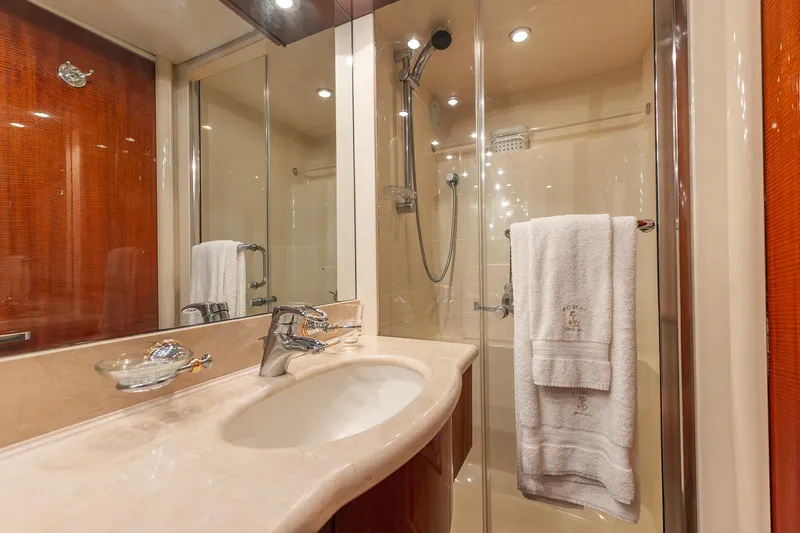Fomo2 Yacht Photos Pics Luxurious bathroom in 2002 Lazzara 80 Skylounge yacht with elegant fixtures and glass shower.
