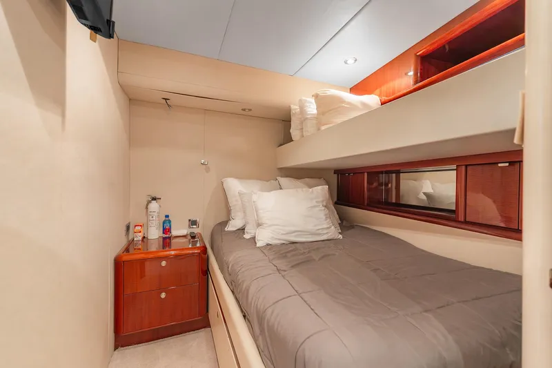 Fomo2 Yacht Photos Pics Cozy bedroom in 2002 Lazzara 80 Skylounge yacht with bunk beds and wooden accents.