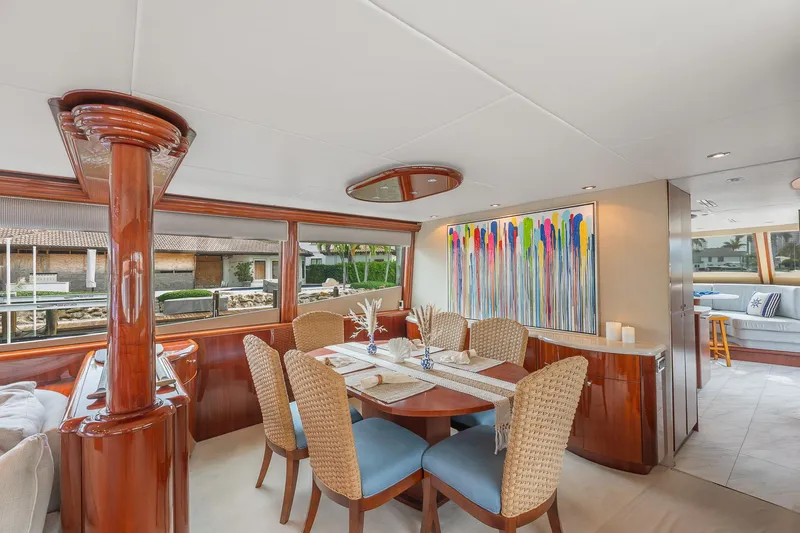 Fomo2 Yacht Photos Pics Luxurious dining area on 2002 Lazzara 80 Skylounge yacht with modern art and elegant furnishings.
