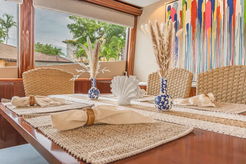 Fomo2 Yacht Photos Pics Elegant dining area on 2002 Lazzara 80 Skylounge yacht with artistic decor and woven chairs.