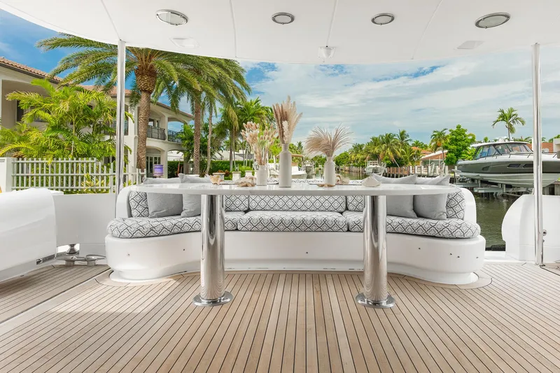 Fomo2 Yacht Photos Pics Luxurious 2002 Lazzara 80 Skylounge yacht deck with elegant seating and scenic waterfront view.