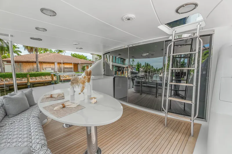 Fomo2 Yacht Photos Pics Luxurious 2002 Lazzara 80 Skylounge yacht deck with elegant seating and dining area.