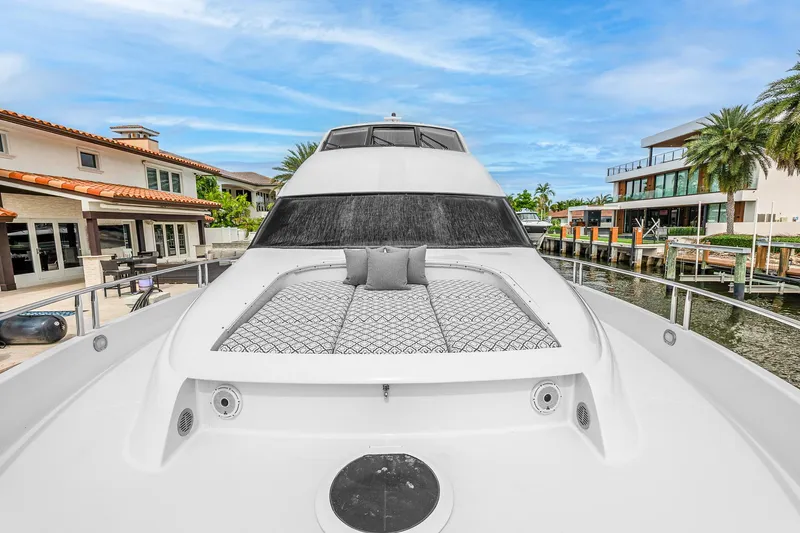 Fomo2 Yacht Photos Pics 2002 Lazzara 80 Skylounge yacht with sunbathing area, docked near luxury waterfront homes.