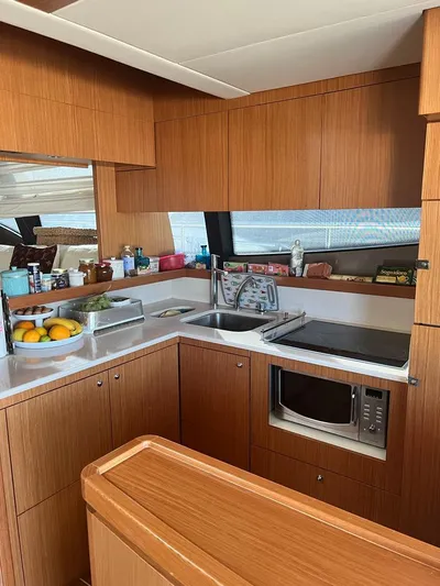  Yacht Photos Pics 2008 Ferretti Yachts 592 kitchen with wood cabinetry, modern appliances, and countertop fruit display.