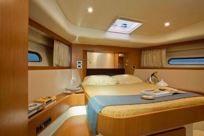  Yacht Photos Pics Luxurious cabin interior of 2008 Ferretti Yachts 592, featuring a cozy bed and elegant wood finishes.