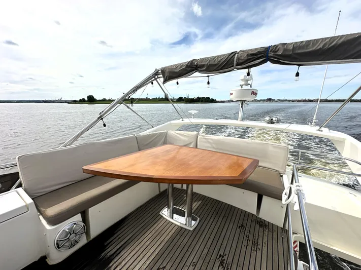  Yacht Photos Pics Prestige 500 yacht deck with wooden table, cushioned seating, and scenic water view, 2013 model.