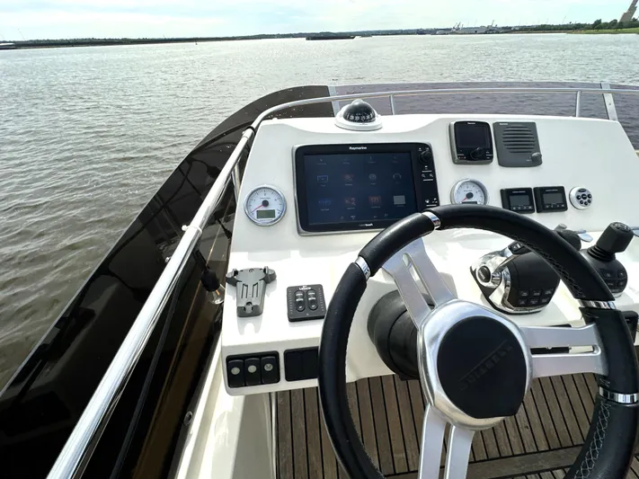  Yacht Photos Pics Steering console of a 2013 Prestige 500 yacht with navigation controls on open water.