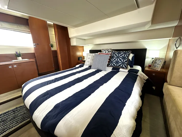  Yacht Photos Pics Luxurious bedroom interior of a 2013 Prestige 500 yacht with striped bedding.