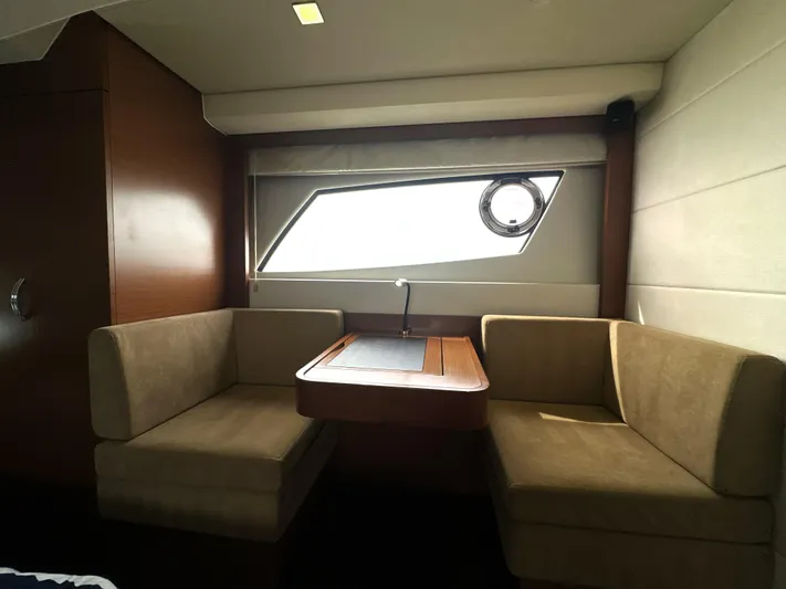  Yacht Photos Pics Interior of a 2013 Prestige 500 yacht with cozy seating and a window view.