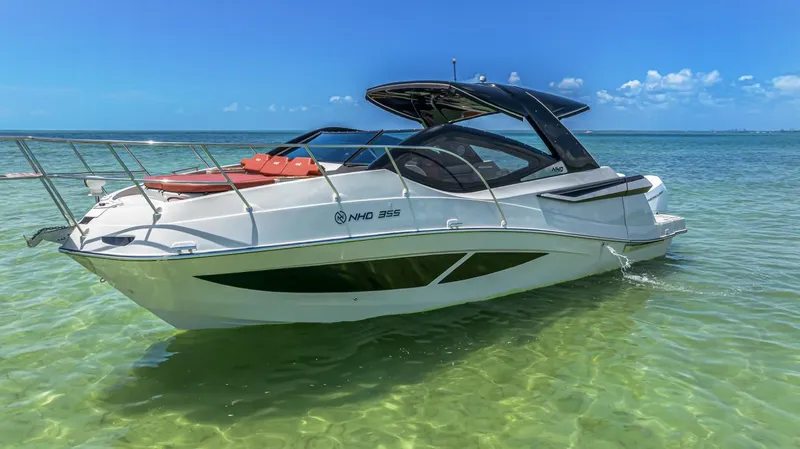  Yacht Photos Pics 2024 NHD 355 Open Deck boat on clear water under blue sky.