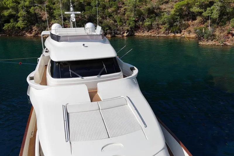  Yacht Photos Pics Luxurious 2011 Custom Line Navetta 26 yacht docked in serene waters near lush greenery.