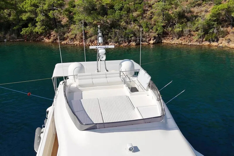  Yacht Photos Pics Custom Line Navetta 26 yacht, 2011 model, anchored in serene waters near a forested shoreline.