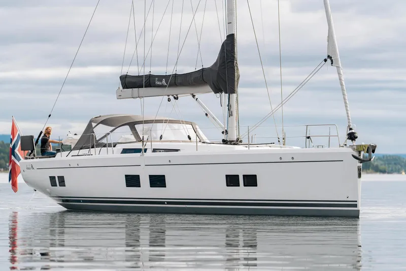  Yacht Photos Pics 2019 Hanse 548 yacht sailing on calm waters with a Norwegian flag.