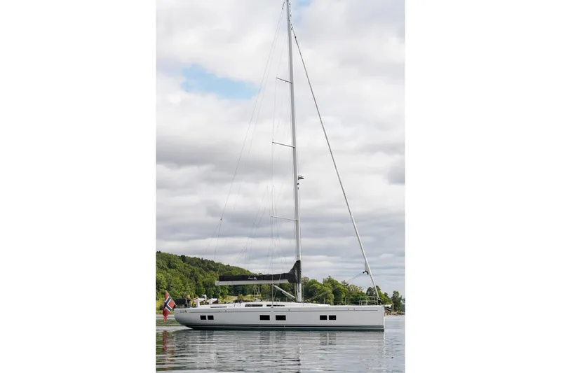  Yacht Photos Pics 2019 Hanse 548 yacht on calm water with lush green shoreline.