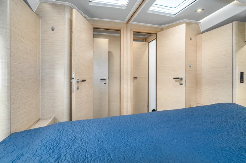  Yacht Photos Pics Luxurious interior of 2019 Hanse 548 yacht with blue bedding and modern wood finish.