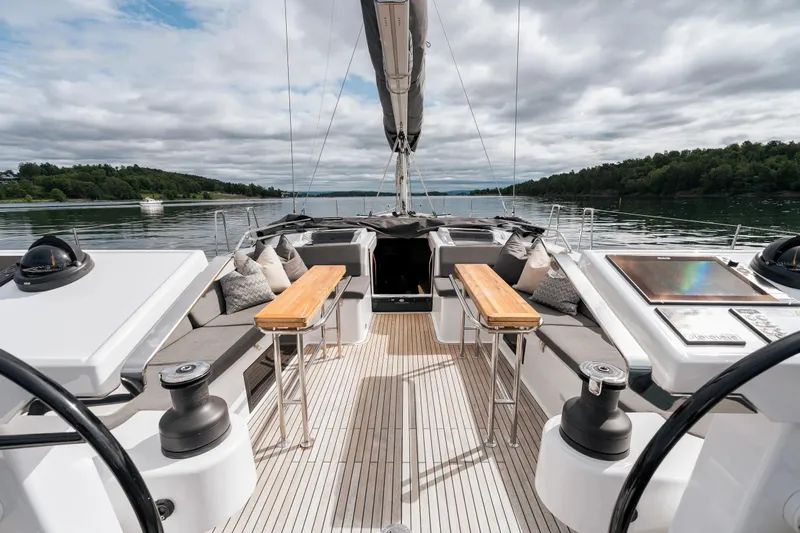  Yacht Photos Pics Luxurious 2019 Hanse 548 yacht deck with seating, tables, and scenic water view.