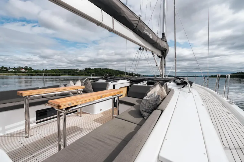  Yacht Photos Pics Luxurious 2019 Hanse 548 yacht deck with seating, tables, and scenic water view.