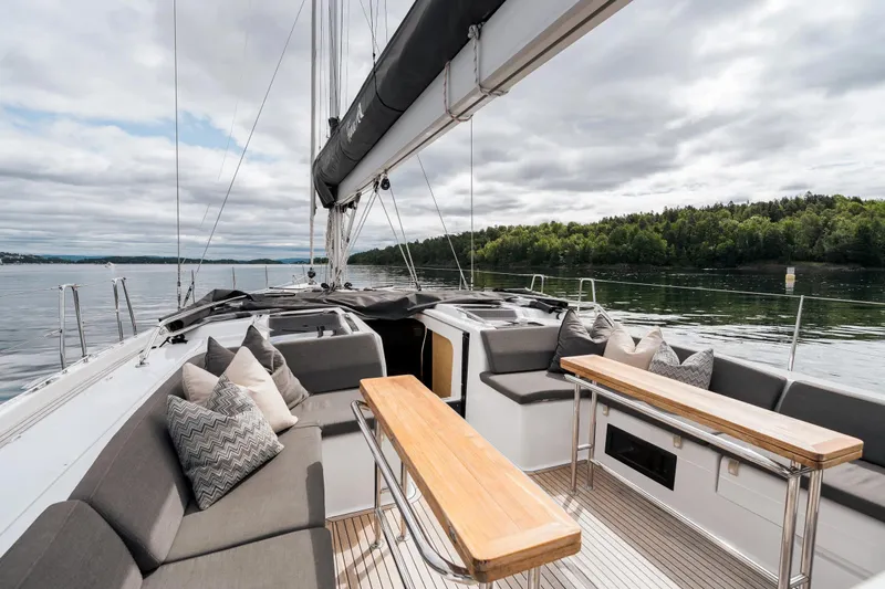  Yacht Photos Pics 2019 Hanse 548 yacht deck with seating, tables, and scenic water view.