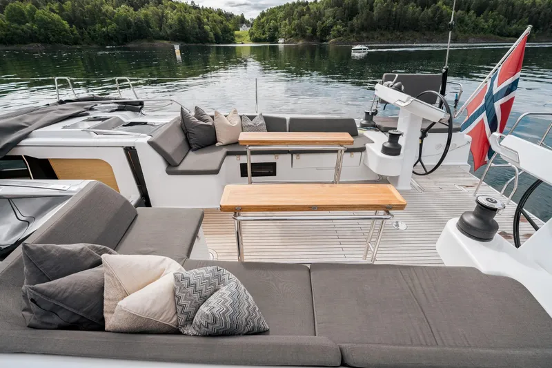  Yacht Photos Pics Luxurious 2019 Hanse 548 yacht deck with comfortable seating and scenic water view.