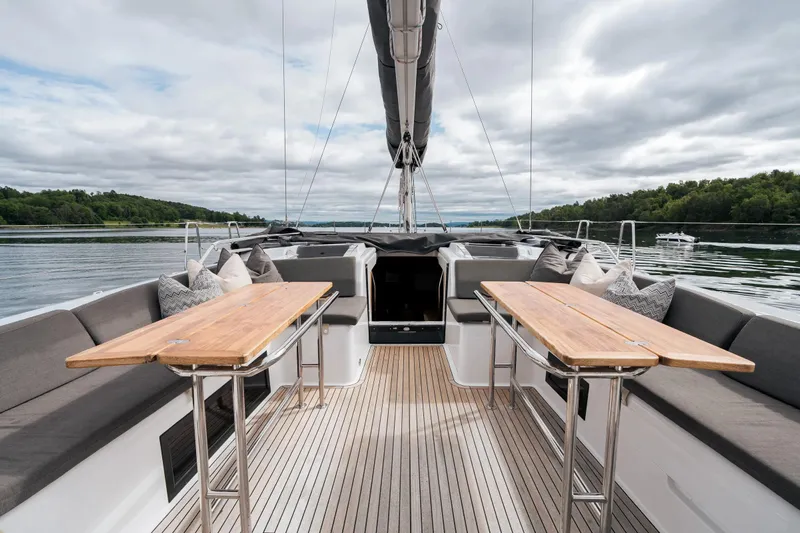  Yacht Photos Pics Luxurious 2019 Hanse 548 yacht deck with wooden tables and cushioned seating.