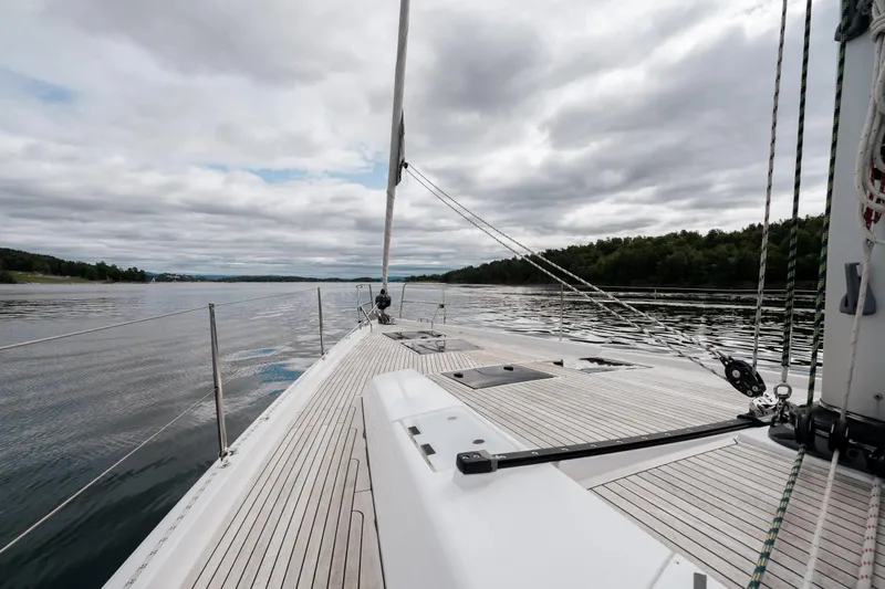  Yacht Photos Pics 2019 Hanse 548 yacht sailing on calm waters under cloudy skies.
