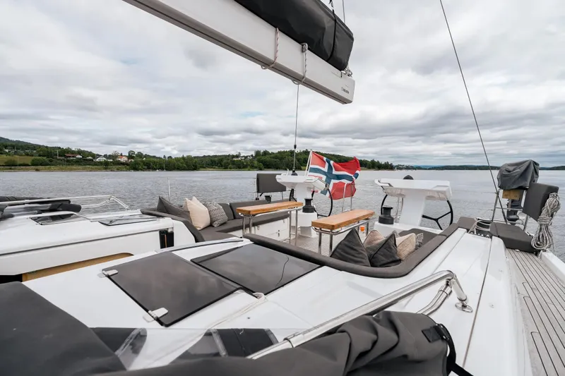  Yacht Photos Pics Luxurious 2019 Hanse 548 yacht with Norwegian flag, spacious deck, and scenic waterfront view.