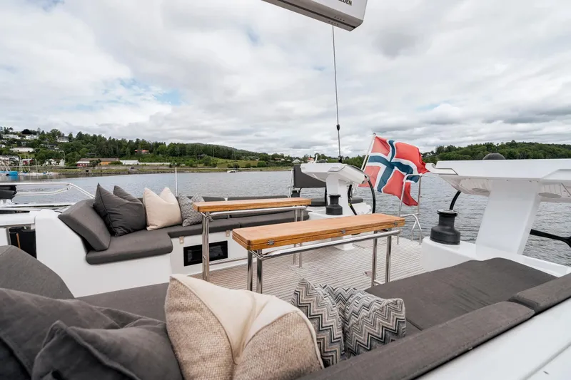  Yacht Photos Pics Luxurious 2019 Hanse 548 yacht deck with comfortable seating and scenic waterfront view.