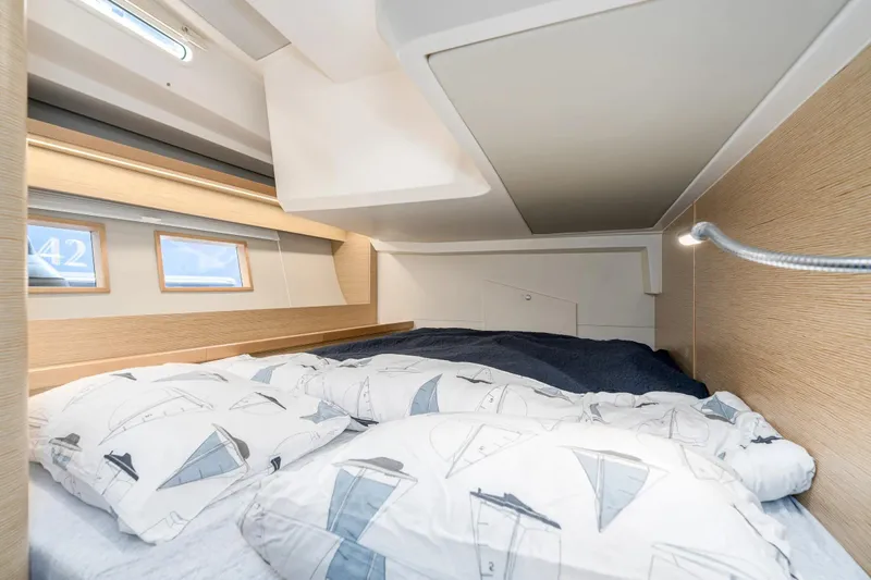  Yacht Photos Pics Cozy cabin interior of 2019 Hanse 548 yacht with nautical-themed bedding.