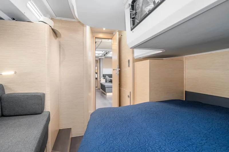  Yacht Photos Pics Interior of 2019 Hanse 548 yacht, featuring modern design with cozy seating and blue bedding.