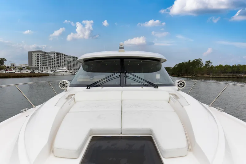 Segers Marine Yacht Photos Pics 2019 Tiara Yachts C49 Coupe on water, cityscape and trees in background.