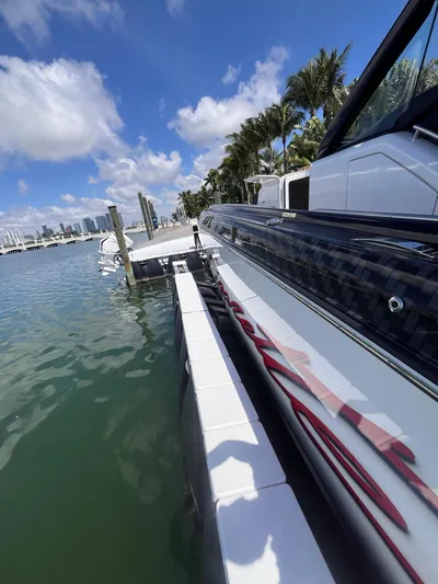  Yacht Photos Pics 2024 Cigarette 42 Auroris boat docked by palm trees under a clear blue sky.