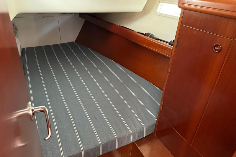 Interlude Yacht Photos Pics Cozy cabin interior of 2002 Beneteau Oceanis 393 sailboat with striped bedding.