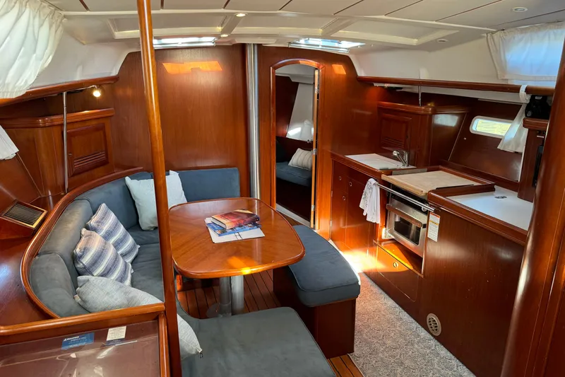 Interlude Yacht Photos Pics Interior of 2002 Beneteau Oceanis 393 sailboat with cozy seating and kitchen area.