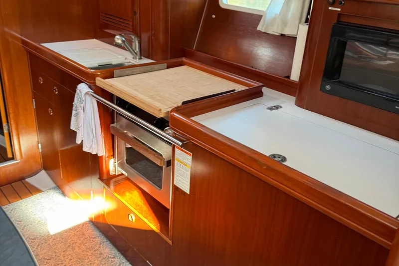 Interlude Yacht Photos Pics 2002 Beneteau Oceanis 393 yacht kitchen with wood cabinetry and modern appliances.