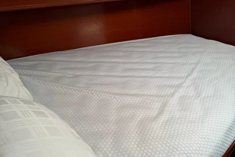 Interlude Yacht Photos Pics Cozy cabin bed in 2002 Beneteau Oceanis 393 sailboat, featuring white bedding.