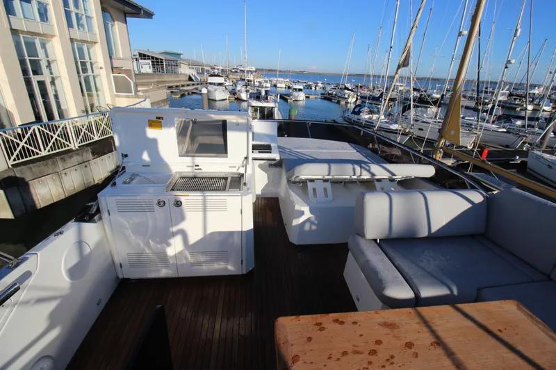  Yacht Photos Pics Luxurious 2024 Prestige 520 yacht deck with seating and grill at marina.