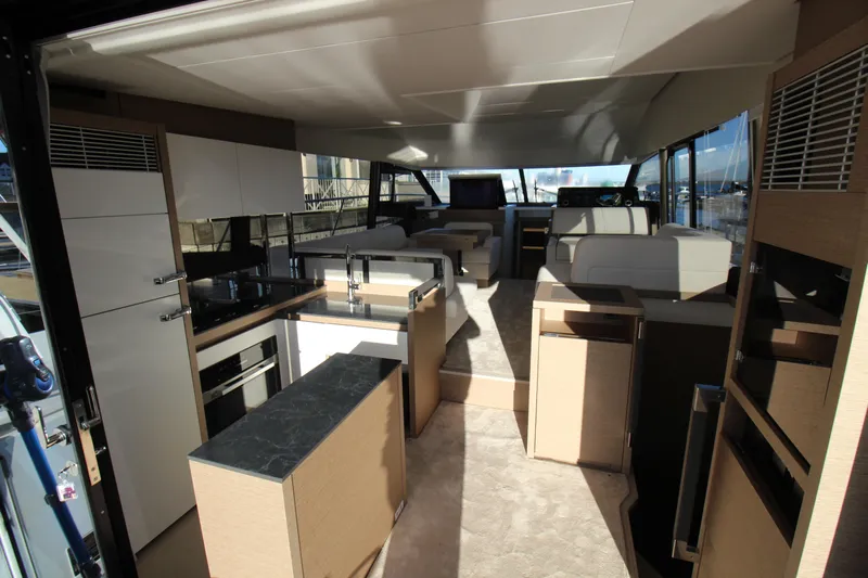  Yacht Photos Pics Luxurious interior of 2024 Prestige 520 yacht with modern kitchen and seating area.