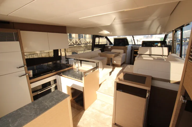  Yacht Photos Pics Luxurious interior of 2024 Prestige 520 yacht with modern kitchen and seating area.