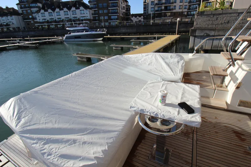  Yacht Photos Pics Prestige 520 yacht deck with covered seating, table, and marina view, 2024 model.