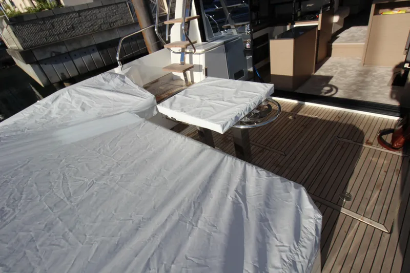  Yacht Photos Pics 2024 Prestige 520 yacht deck with covered seating and table, showcasing luxury design.