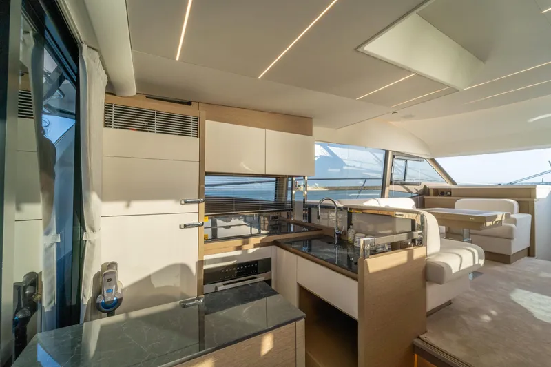  Yacht Photos Pics Luxurious interior of 2024 Prestige 520 yacht with modern kitchen and seating area.