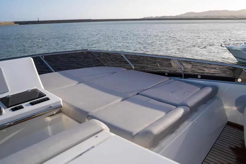  Yacht Photos Pics Luxury 2024 Prestige 520 yacht deck with sun loungers, overlooking serene waters.
