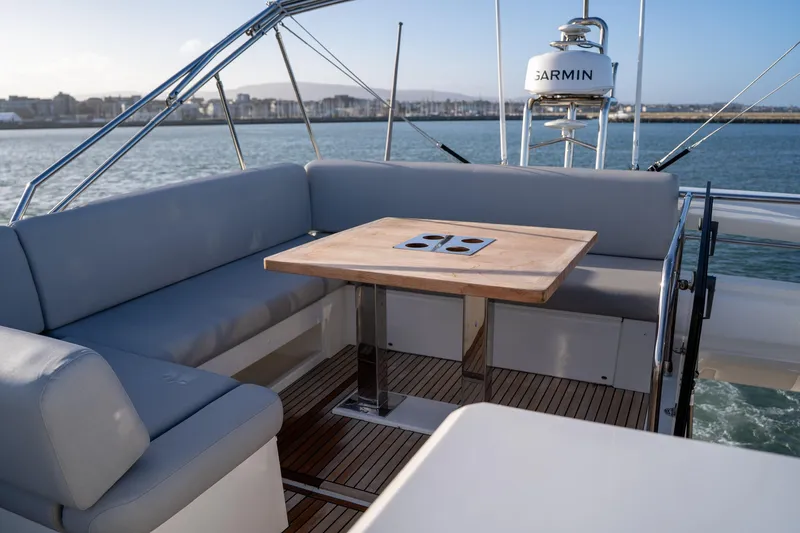  Yacht Photos Pics Luxurious seating area on 2024 Prestige 520 yacht with wooden table and ocean view.
